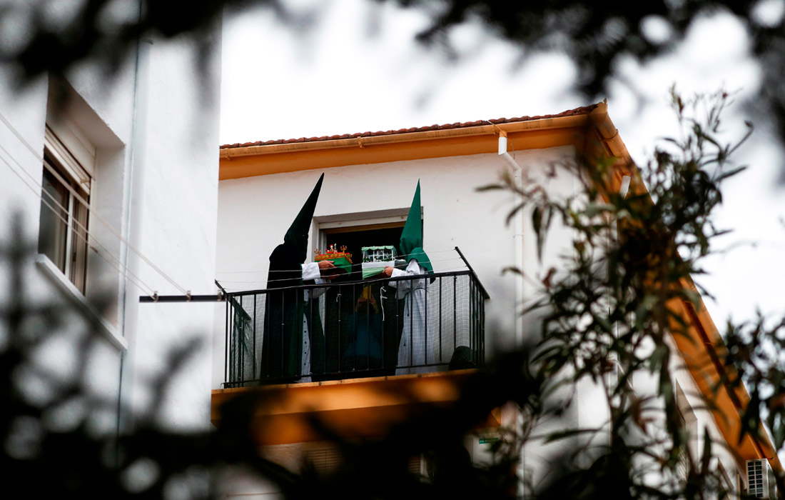 Кающиеся грешники из братства La Columna на балконе в Ронде, Испания