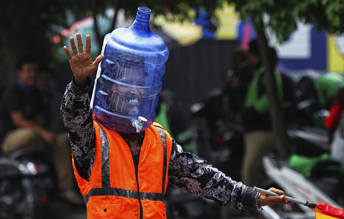 16 апреля. В Индонезии регулировщики движения вынуждены носить баллоны из-под воды из-за дефицита защитных масок и респираторов в стране.