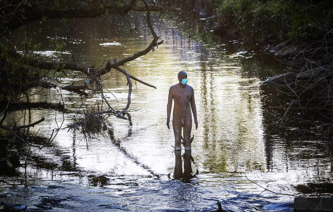 На чугунную статую художника Энтони Гормли надели медицинскую маску в Эдинбурге, Шотландия