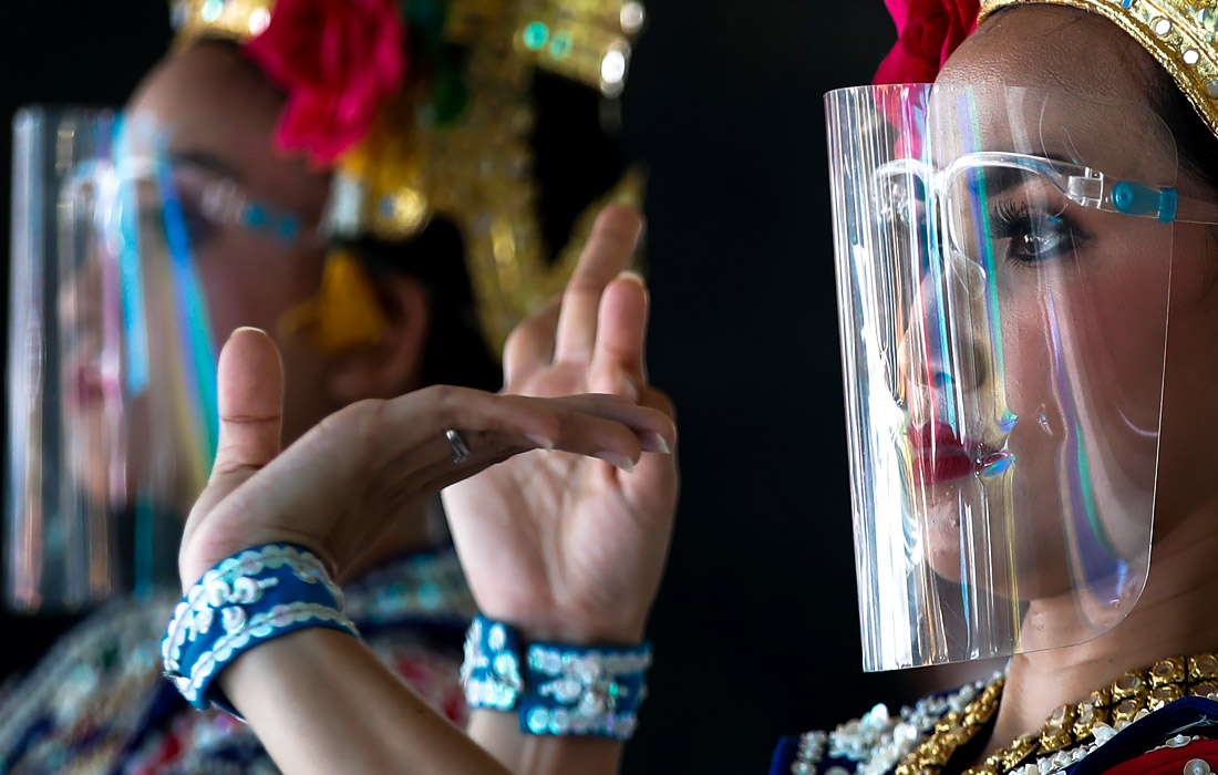 Выступление тайских танцовщиц в защитных экранах в Бангкоке