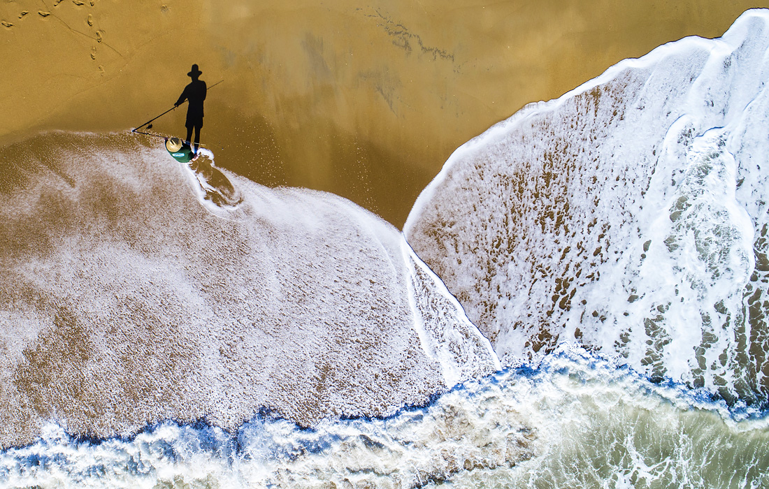 Рыбак на пляже в Северной Каролине, США