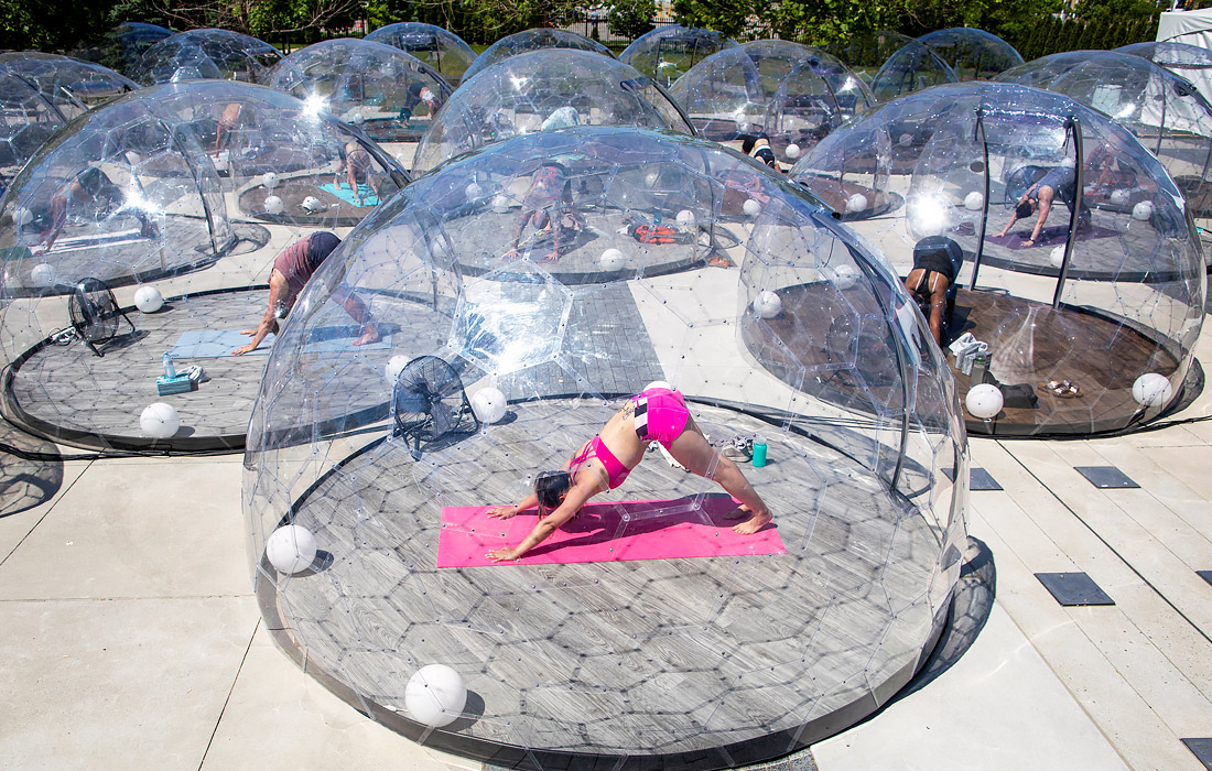 22 июня. Клиенты йога-студии в Торонто занимаются в пластиковых куполах для сохранения социальной дистанции