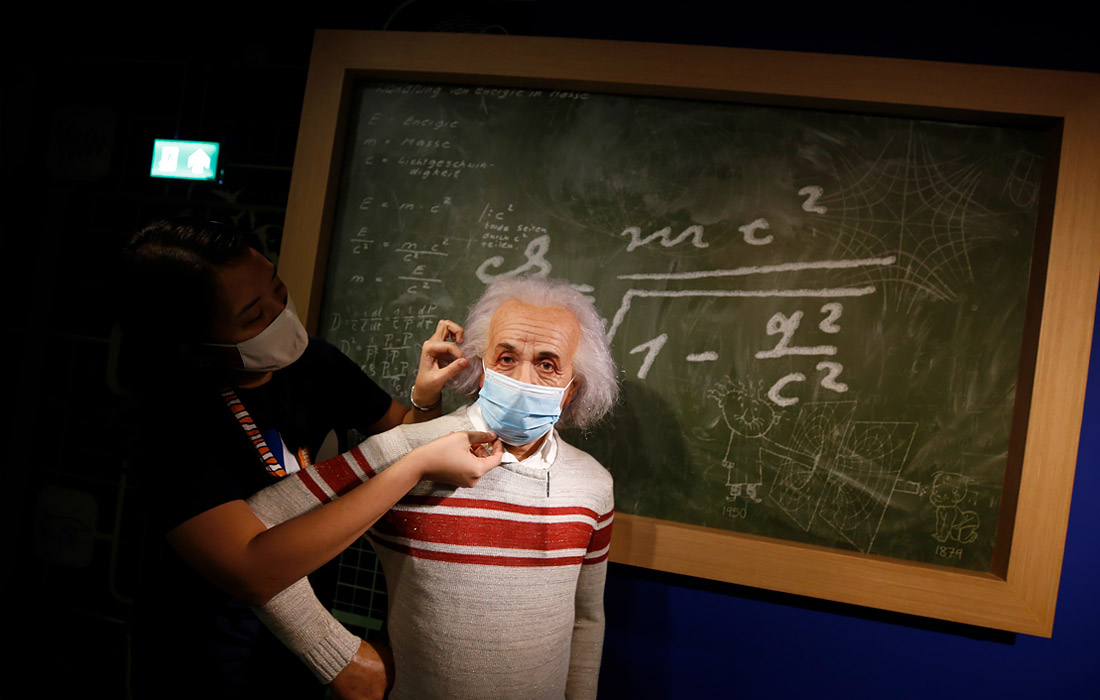 Сотрудник Музея мадам Тюссо в Бангкоке надевает маску на восковую фигуру физика Альберта Эйнштейна