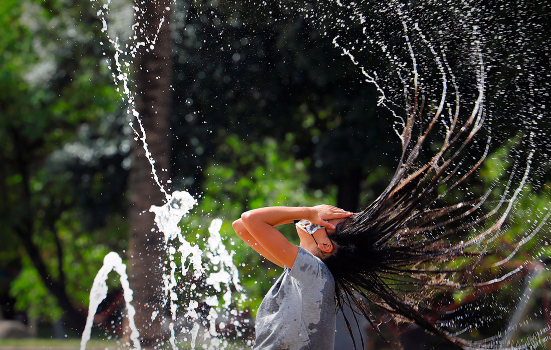 Страны Западной Европы столкнулись с сильной жарой. Температура воздуха во многих странах держится на отметке около 40 градусов по Цельсию. На фото: женщина охлаждается у фонтана в Кордове, Испания.