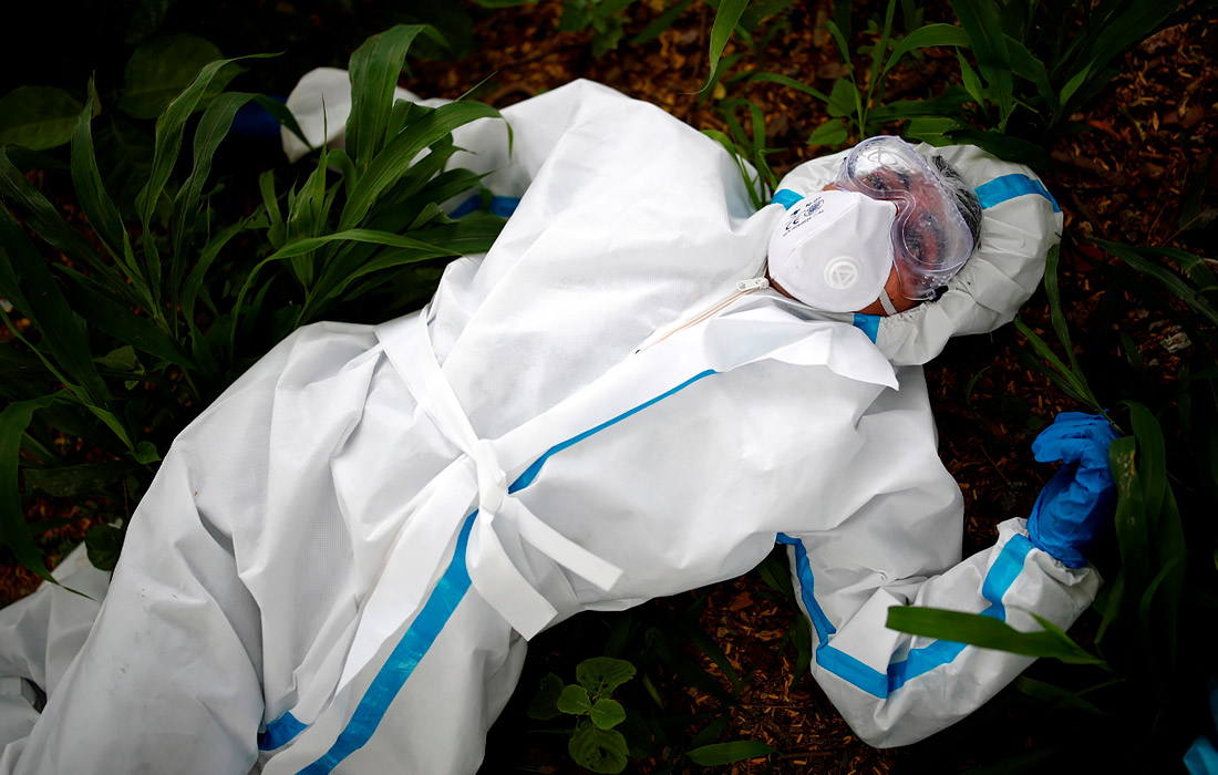 7 августа. В Индии число случаев заражения коронавирусом превысило 2 млн. На фото: медицинский работник отдыхает перед погребением женщины, скончавшейся от COVID-19 на кладбище в Нью-Дели.