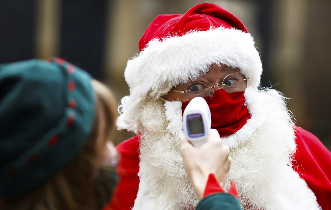 Проверка температуры у учащегося школы Санта-Клаусов в Лондоне
