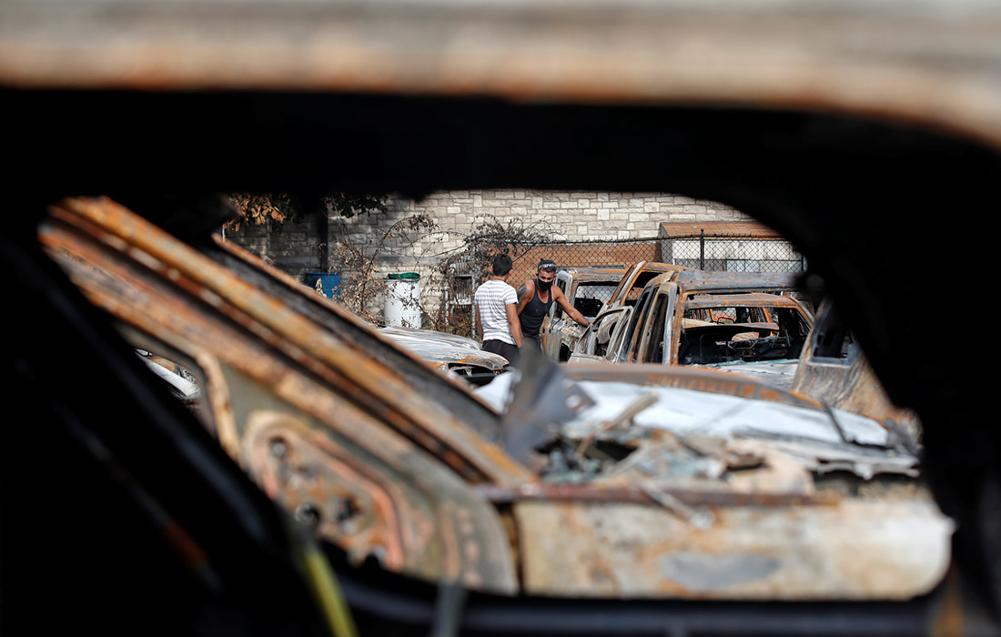 Сотрудники автосалона Car Source оценивают ущерб, причиненный во время беспорядков в американском Кеноше