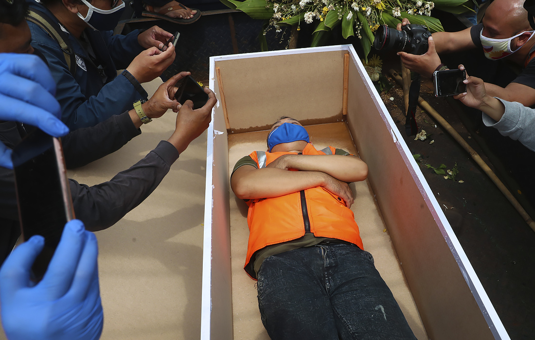 3 сентября. Мужчина лежит в фальшивом гробу в наказание за нарушение правил в индонезийском городе Джакарта. Новые правила требуют от граждан носить маски в общественных местах в качестве меры предосторожности против новой вспышки коронавируса.