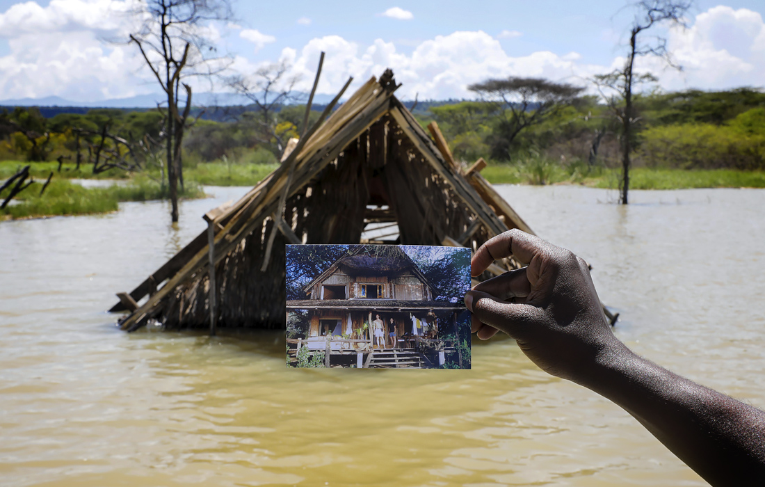 Смотритель показывает фотографию домика до того, как он ушел в воду из-за месяцев необычайно сильных дождей на озере Баринго в Кении