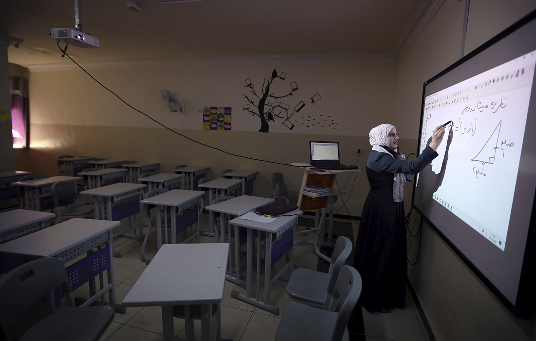Учитель частной школы проводит онлайн-урок для студентов, получающих дистанционное образование, на фоне опасений роста числа случаев COVID-19 в Аммане, Иордания