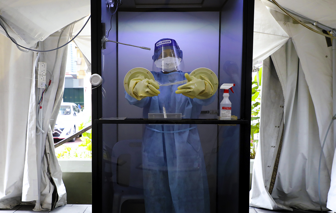 9 октября. Врач ожидает пациента, чтобы взять мазок для тестирования на коронавирусную болезнь в медицинском центре Sunway в Субанг-Джая, Малайзия.