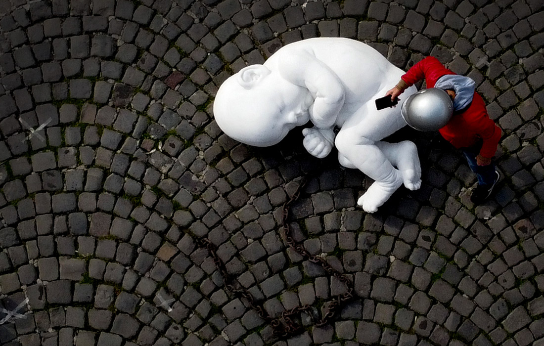 Скульптура из белого мрамора, изображающая свернувшегося калачиком и прикованного цепью младенца, установлена в Неаполе