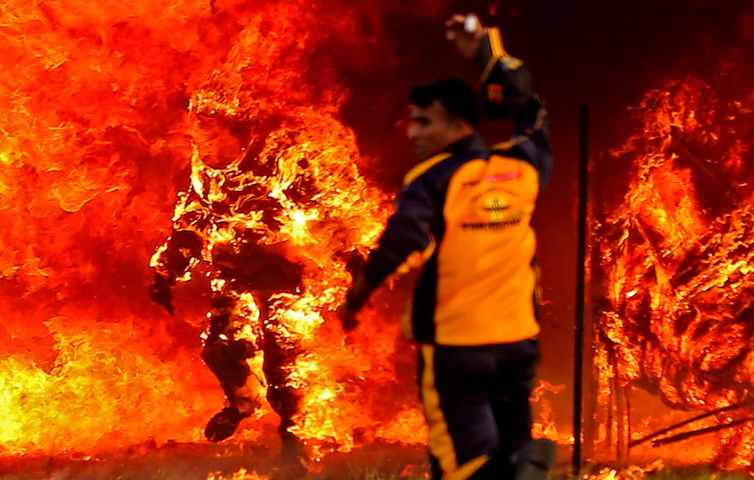 Охваченный пламенем индиец Шивам Сингх в огнеупорном костюме, проехавший на мотоцикле сквозь 127-метровый огненный туннель в попытке установить новый мировой рекорд