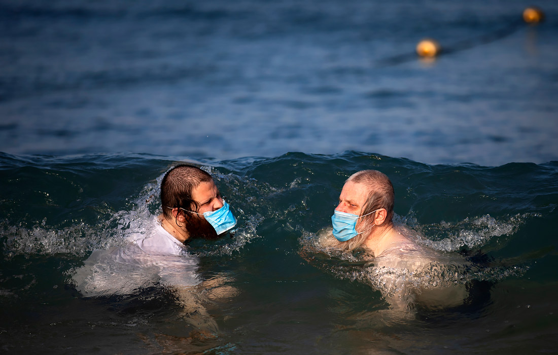9 июля. Ультраортодоксальные евреи плавают в Средиземном море на пляже в Тель-Авиве. В попытке остановить быстрое распространение коронавируса Израиль вновь ввел ряд ограничений для общественности.