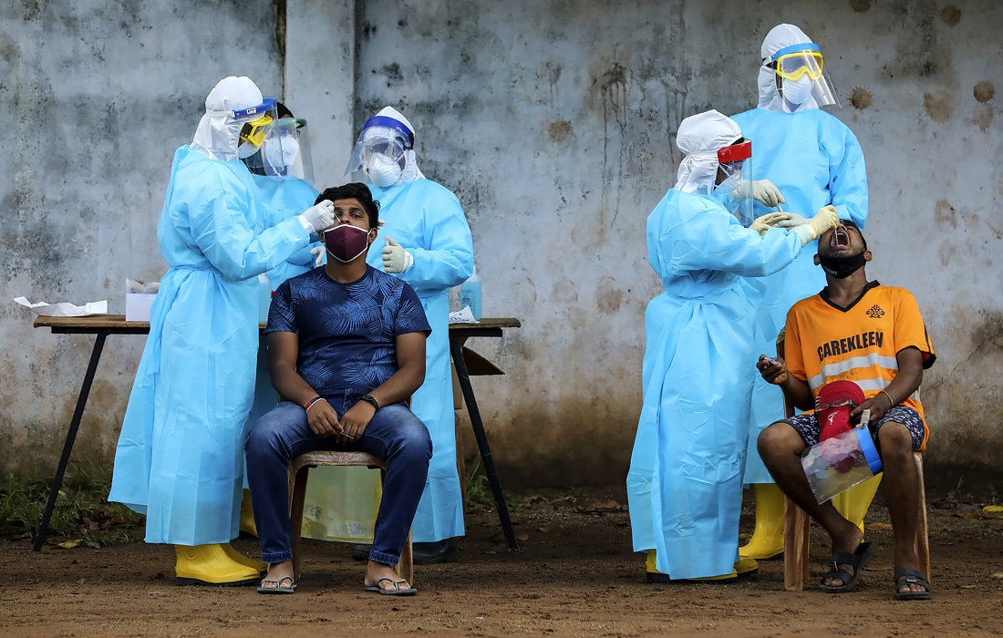 20 ноября. Правительство Шри-Ланки ввело комендантский час в некоторых частях страны после внезапного всплеска заражения на текстильной фабрике и рыбном рынке. На фото: жители закрытых на карантин районов сдают мазки на COVID-19.