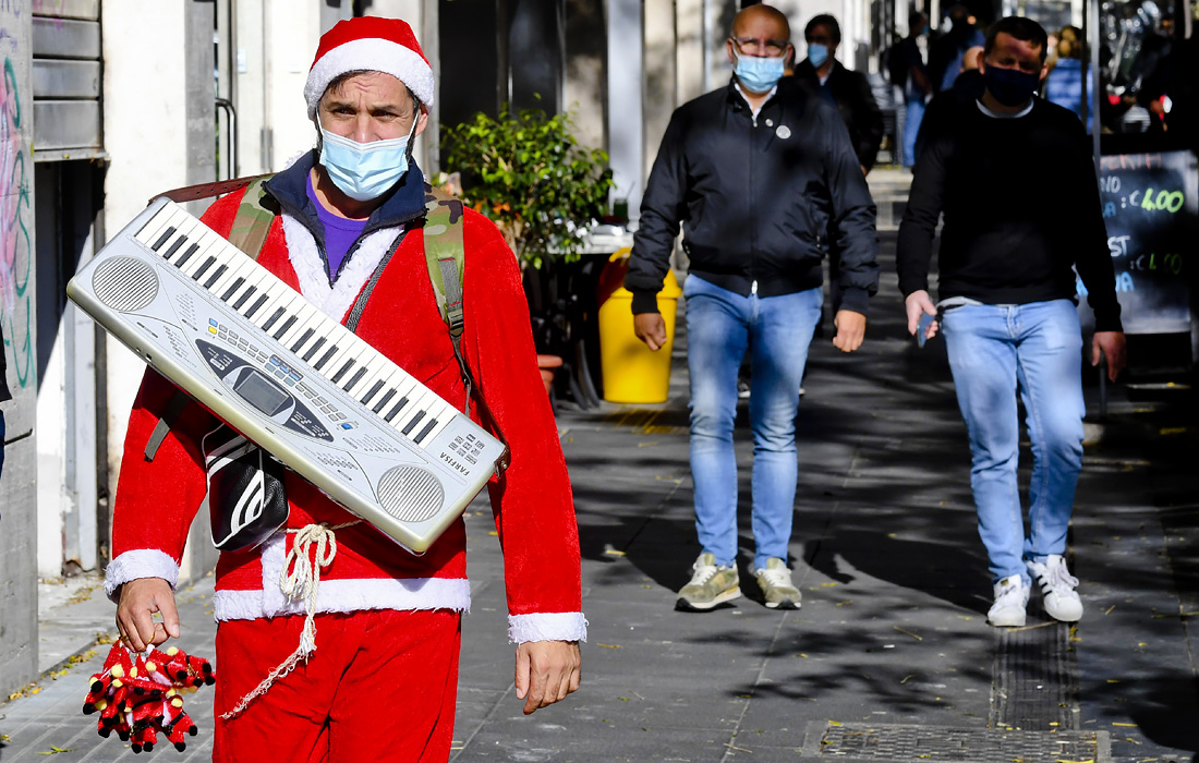 Мужчина в костюме Санта-Клауса исполняет музыку для жителей Неаполя, чтобы оживить будни горожан во время пандемии коронавируса