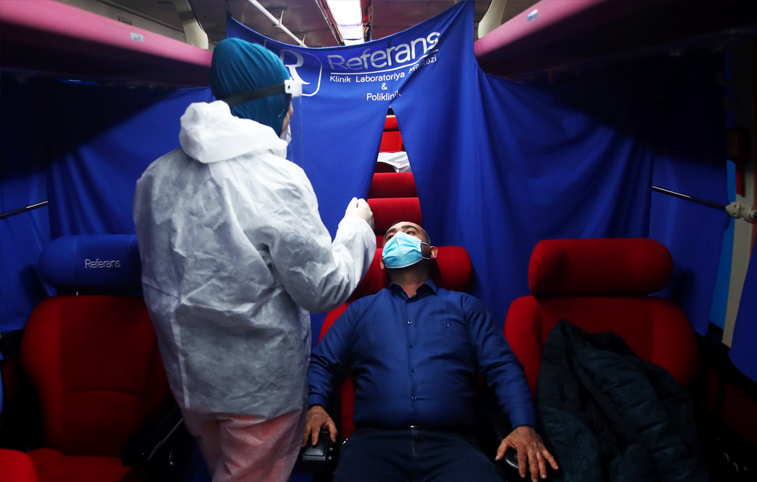 Азербайджан ужесточает карантинный режим из-за коронавируса с 14 декабря. На фото: медицинский работник во время тестирования местного жителя в мобильном пункте в Баку.