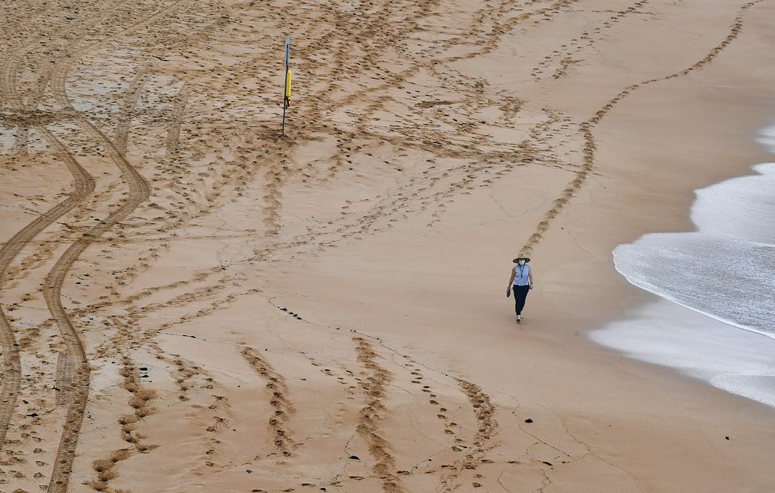 Власти австралийского штата Новый Южный Уэльс призвали сотни тысяч жителей Сиднея остаться дома на три дня в связи с тем, что в этом районе после периода относительно благополучной эпидемиологической ситуации были зафиксированы 28 случаев COVID-19. На фото: почти безлюдный пляж Авалон.