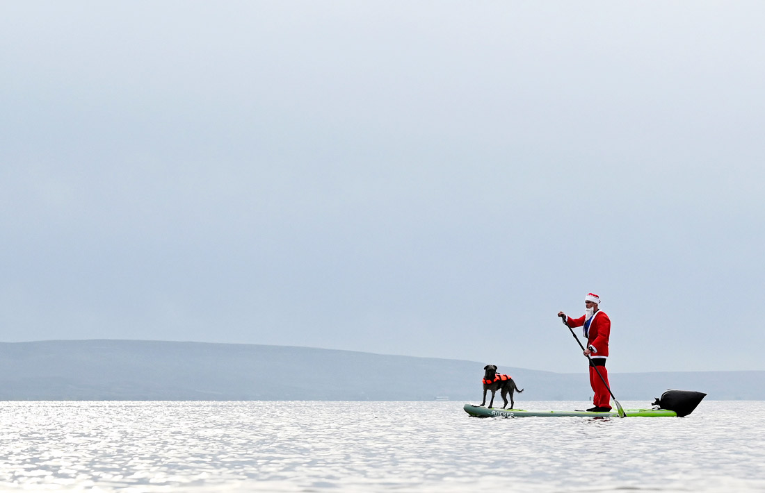 Санта с собакой в заливе Голуэй, Ирландия