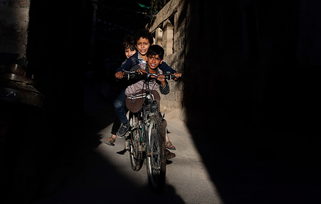 Дети катаются на велосипеде в старом городе Саны, Йемен