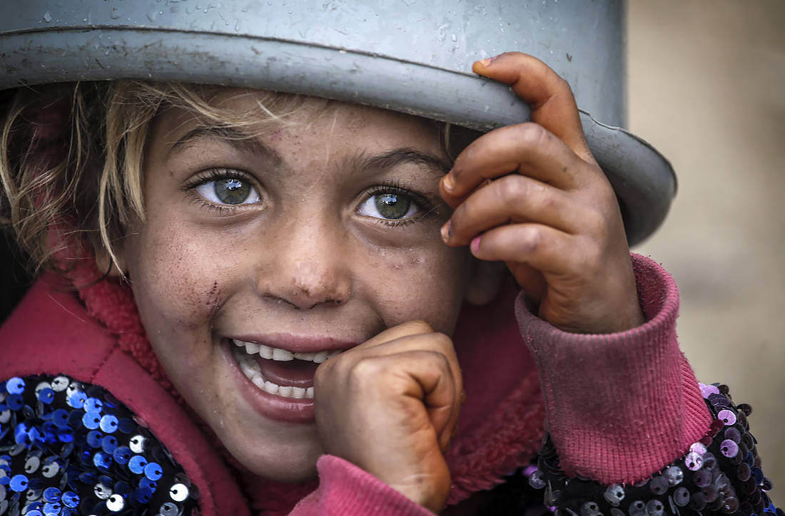Палестинская девочка со своей миской ждет раздачи бесплатной еды на востоке города Газа