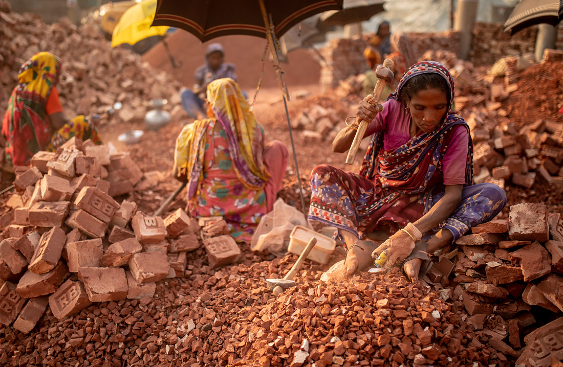 Женщины разбивают кирпичи на заводе в Дакке, Бангладеш. Такая работа приносит им менее пяти долларов в день.