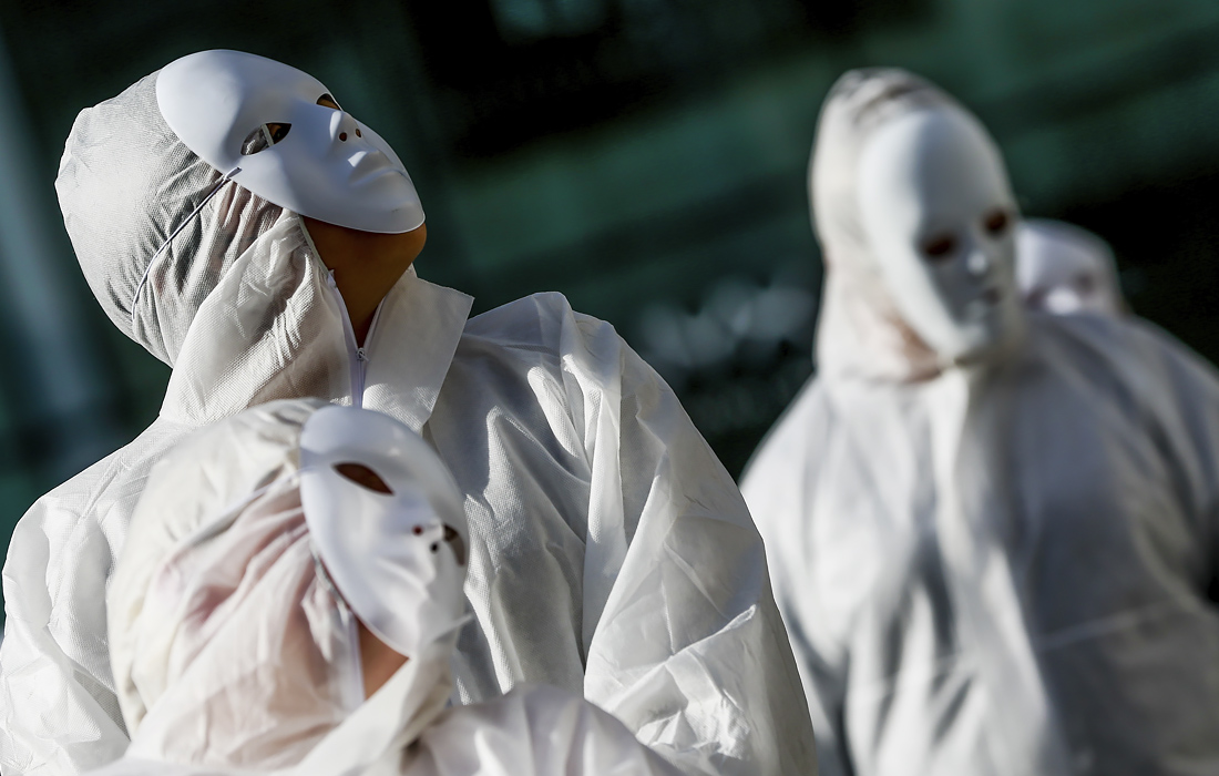 20 февраля. Люди, одетые в защитную одежду, собирались перед театром Ла Монне в знак протеста против карантинных мер, принятых правительством в Брюсселе, Бельгия.