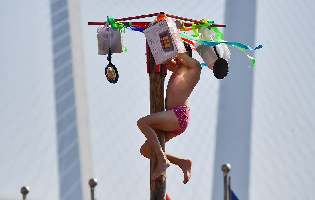 Участник народной забавы "Масленичный столб" во Владивостоке