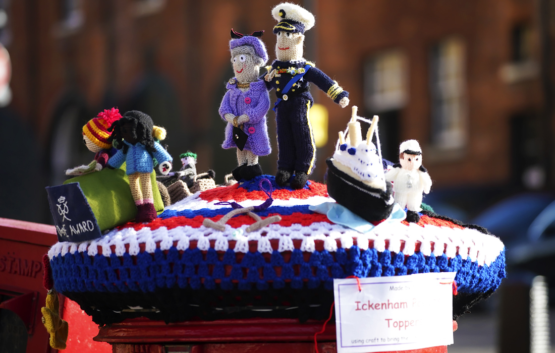 В Великобритании продолжается национальный траур после смерти принца Филиппа. На фото: вязаные фигуры королевы Елизаветы II и ее мужа принца Филиппа украшают почтовый ящик в Виндзоре.