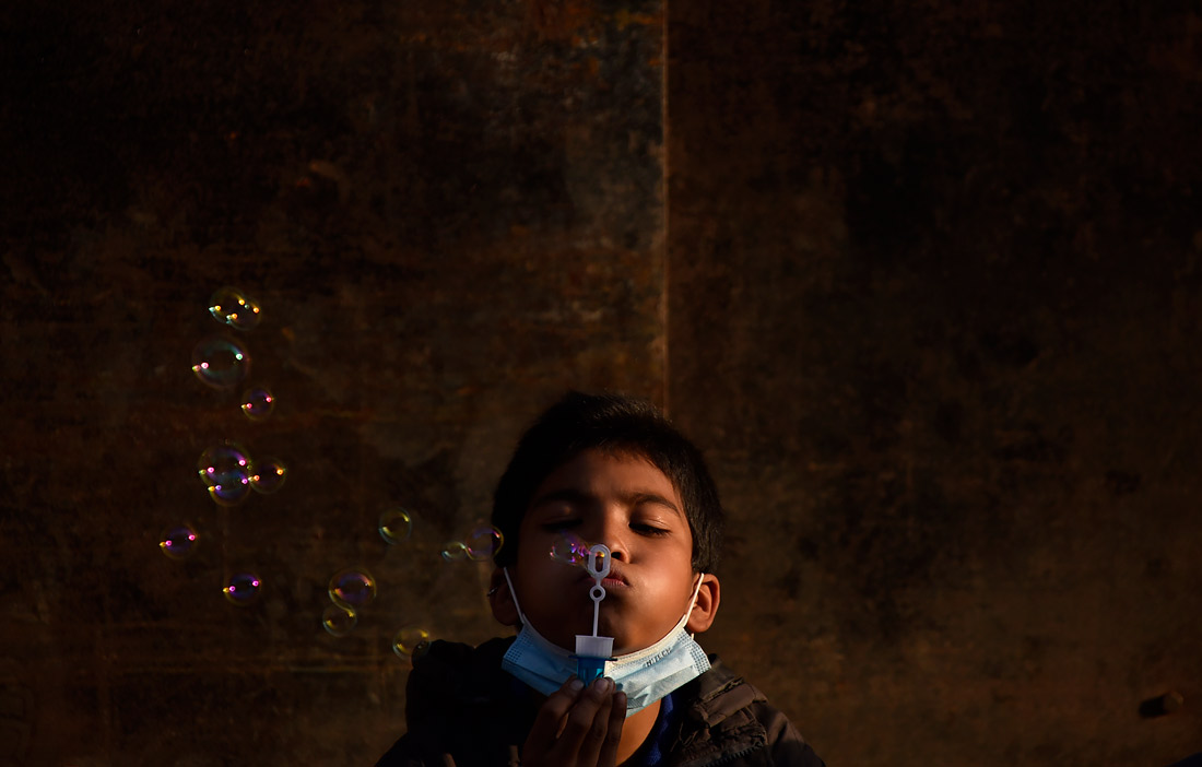 Мальчик надувает мыльные пузыри на улицах Бхактапура, Непал