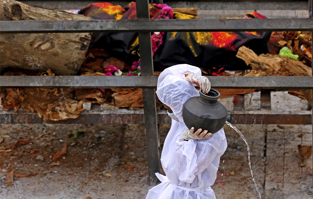 5 мая. Родственники совершают обряды во время похорон на месте массовой кремации на окраине Бангалора, Индия.