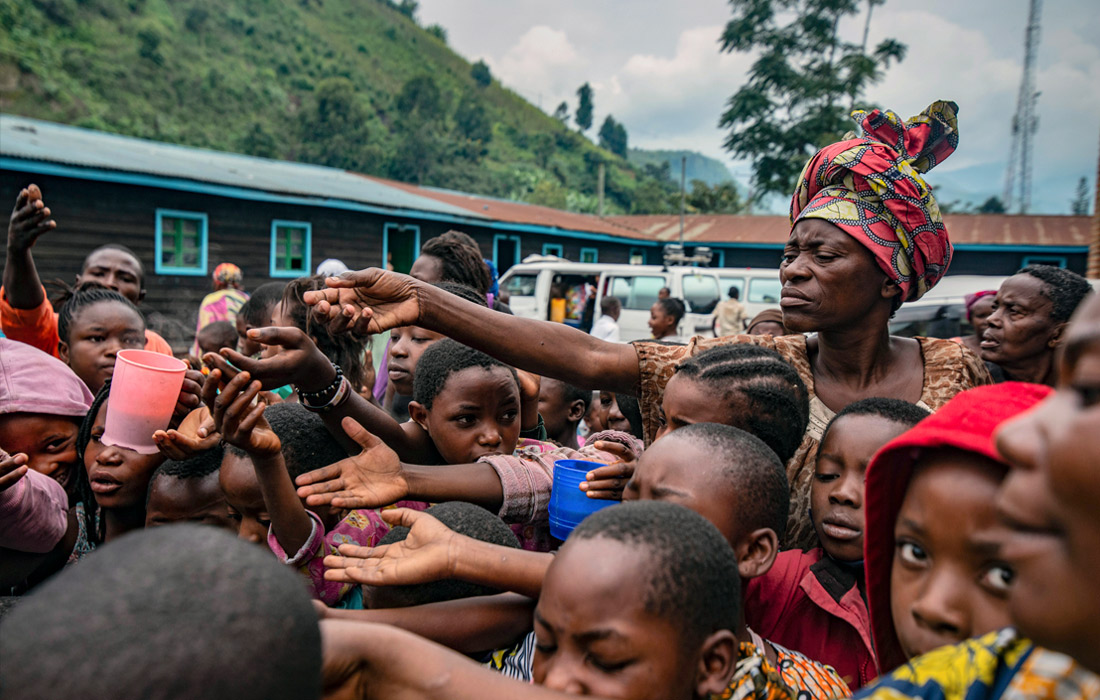 Власти Демократической Республики Конго провели эвакуацию населения города Гома из-за извержения вулкана Ньирагонго, одного из самых активных и опасных вулканов в мире. На фото: беженцы из Гомы в пункте раздачи еды.
