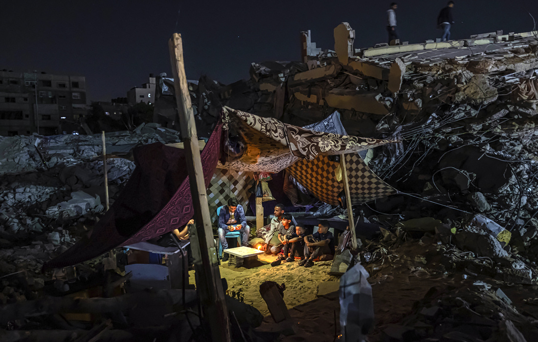 Палестинцы в палатке, установленной на руинах здания в городе Газа