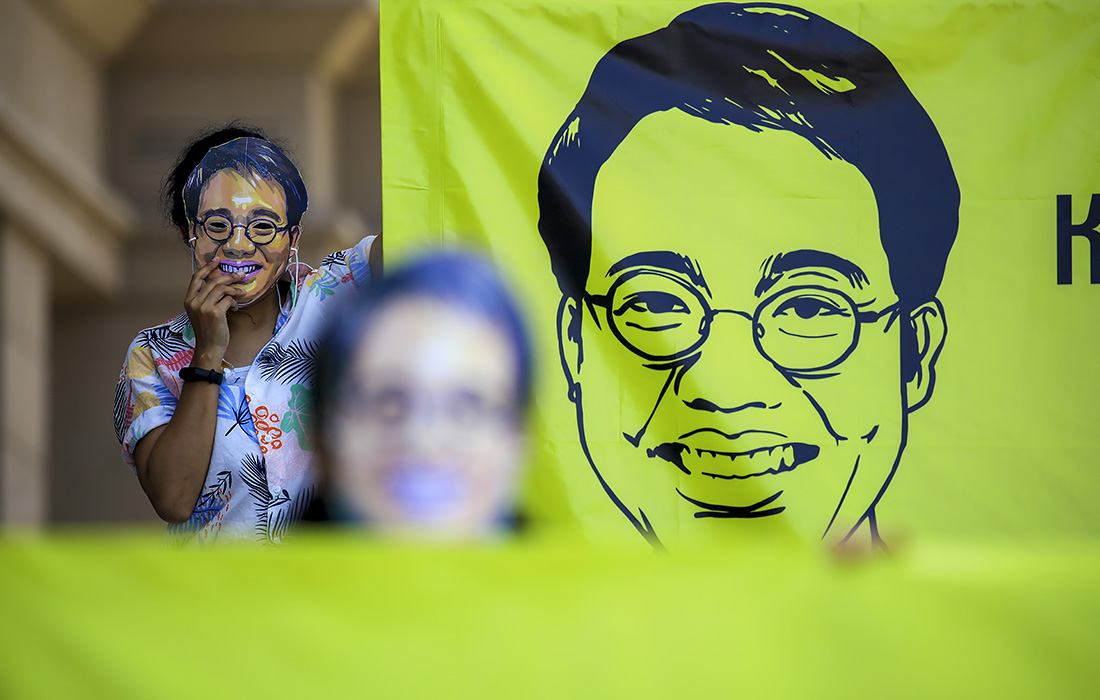 Члены Amnesty International в масках пропавшего тайского активиста Ванчалеарма Сацаксита проводят демонстрацию в годовщину его исчезновения в Бангкоке