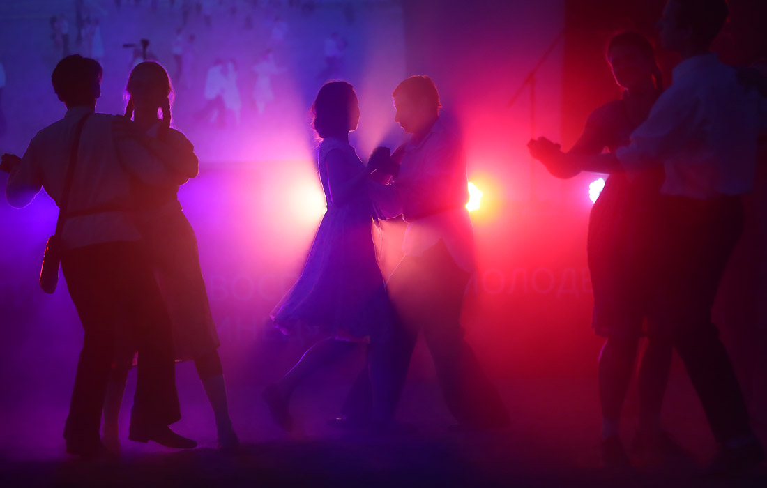 Жители города во время танцев в рамках акции "Свеча памяти" у Троицкого моста в Санкт-Петербурге