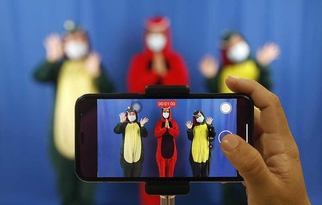 Тайские учителя в костюмах динозавров записывают онлайн-урок для учеников младших классов в школе Бангкока