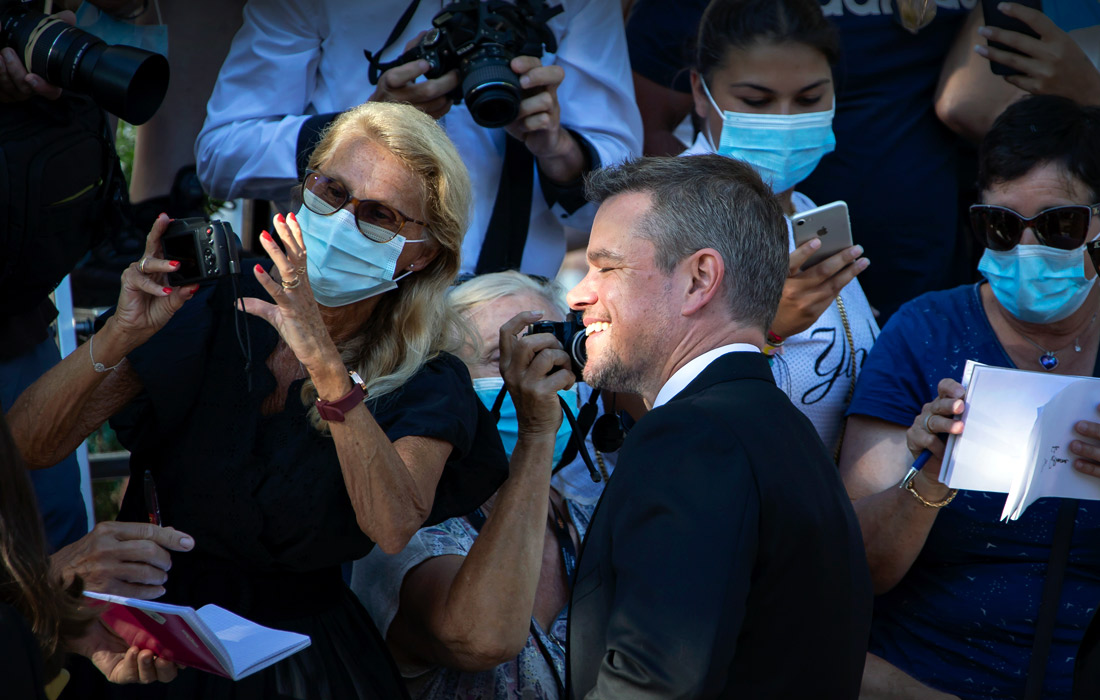 Актер Мэтт Дэймон раздает автографы на красной ковровой дорожке кинофестиваля