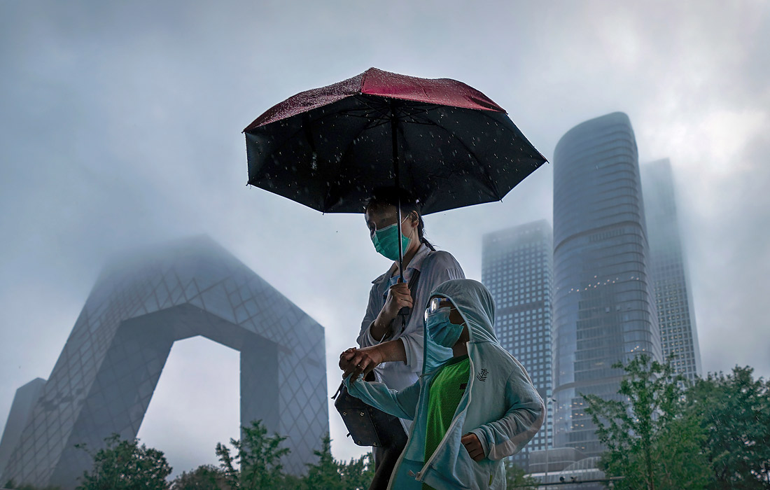 11 июля. Число заразившихся COVID-19 в мире превысило 186,8 млн человек. На фото: жители Пекина во время дождя.