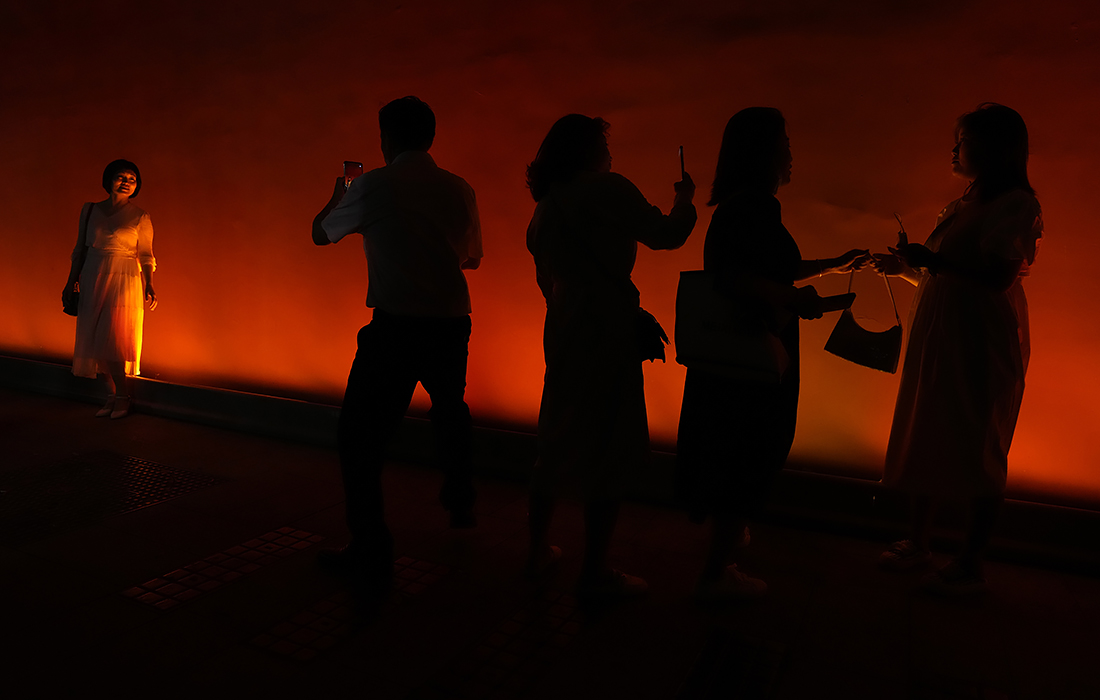 Посетители фотографируются у красных стен возле ворот Тяньаньмэнь в Пекине