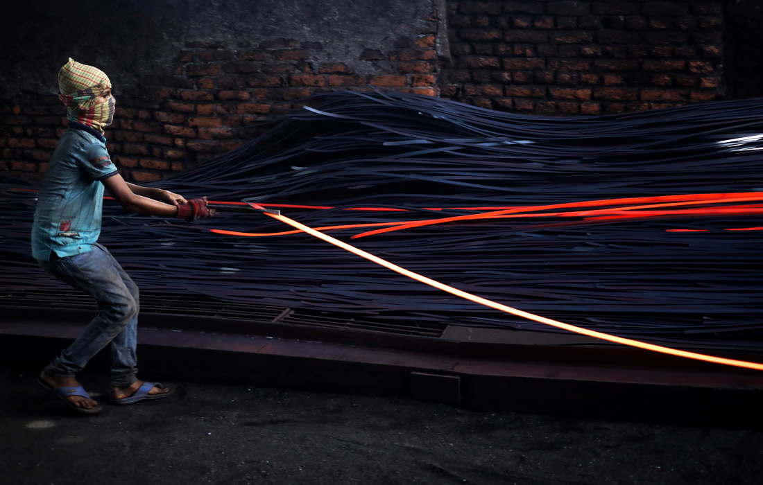 Двенадцатилетний житель Дакки работает на заводе по переработке железа, Бангладеш