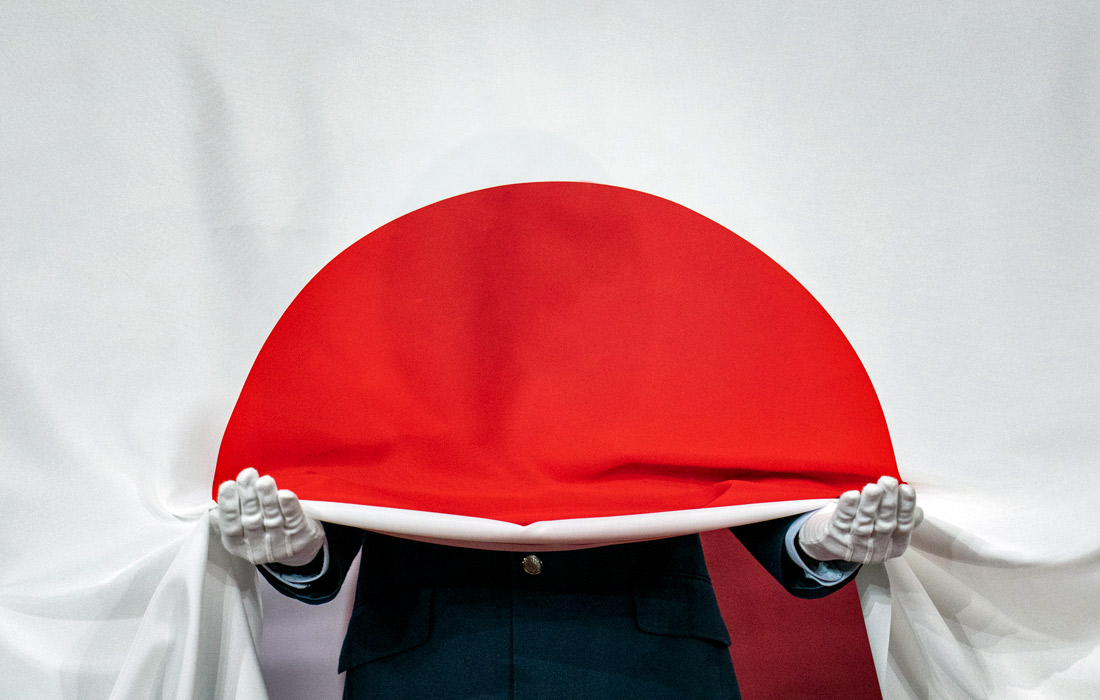 Солдат сил самообороны Японии держит национальный флаг