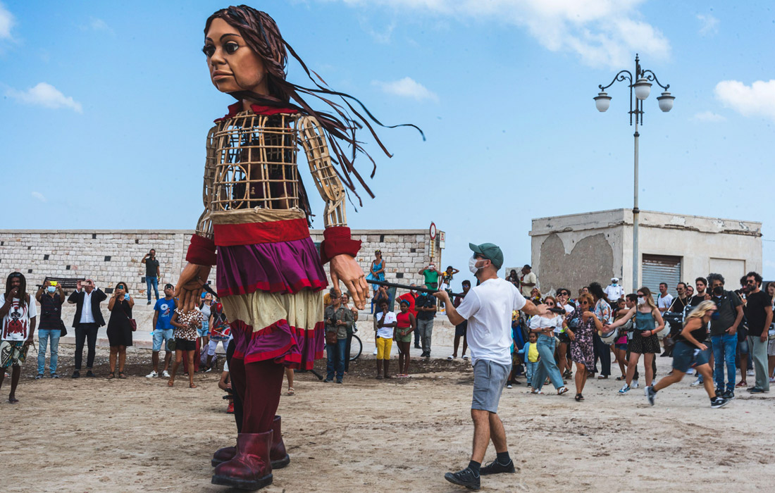 Кукла высотой 3,5 метра, символизирующая девочку-беженку из Сирии, совершает путешествие длиной 8000 км от сирийско-турецкой границы до Великобритании. Проект призван привлечь внимание общества к миграционному кризису.