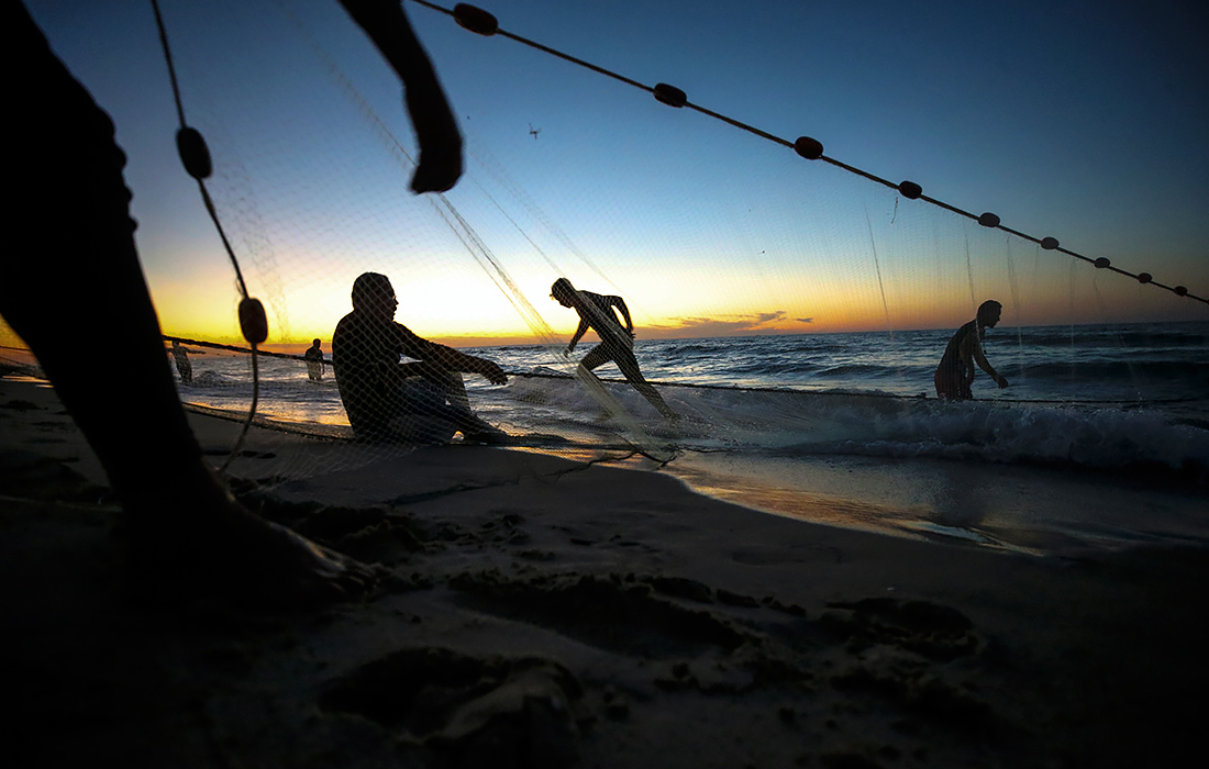 Палестинские беженцы ловят рыбу на пляже к западу от города Газа