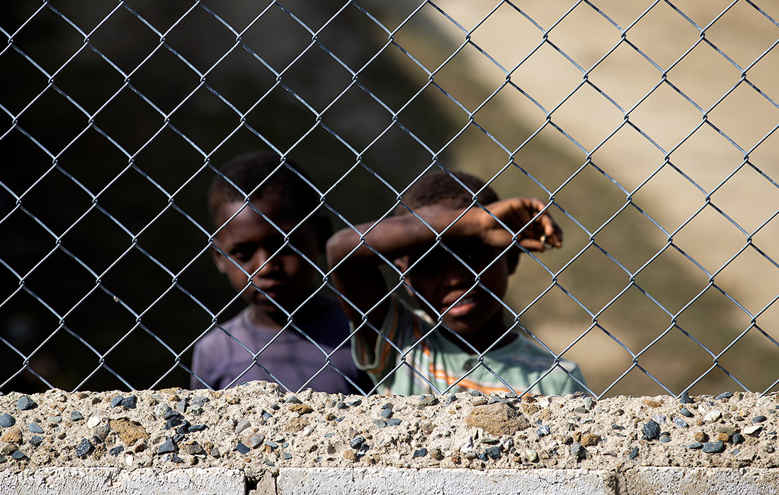 Доминиканские военные усиливают наблюдение на границе с Гаити. Соседний Гаити сейчас переживает одну из крупнейших волн насилия за последнее время. На фото: двое гаитянских детей на границе.