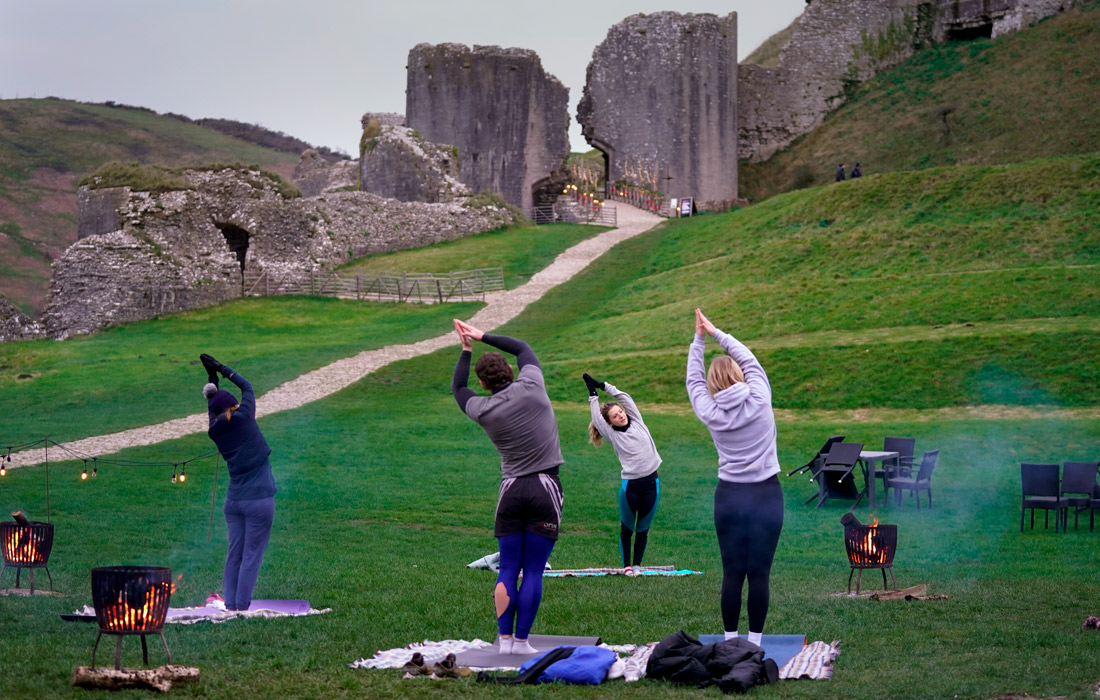 Занятия йогой в День зимнего солнцестояния возле замка Корф в английском графстве Дорсет