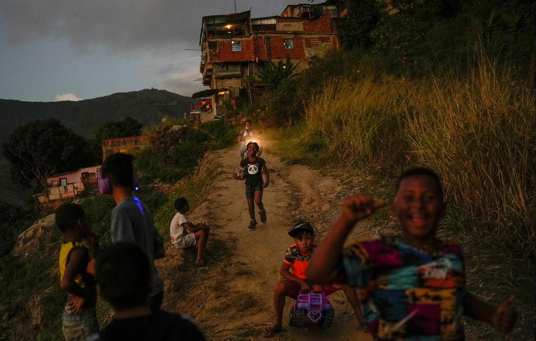 Дети играют с футбольным мячом в Каракасе, Венесуэла