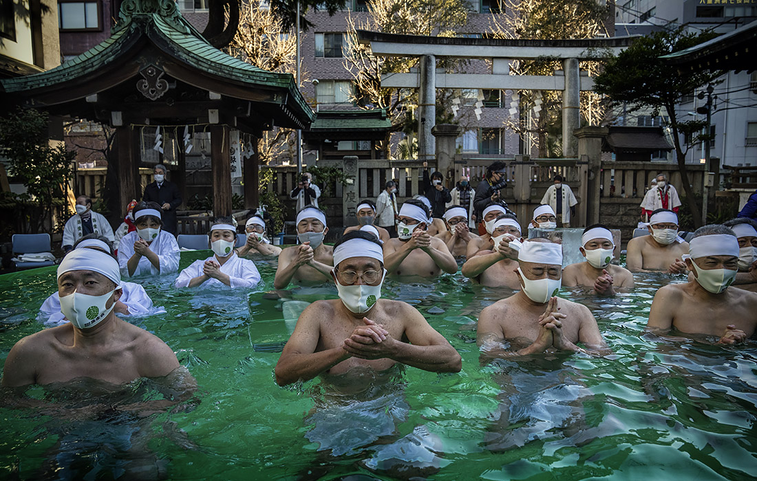 Японские верующие очищаются ледяной водой у синтоистского храма в Токио