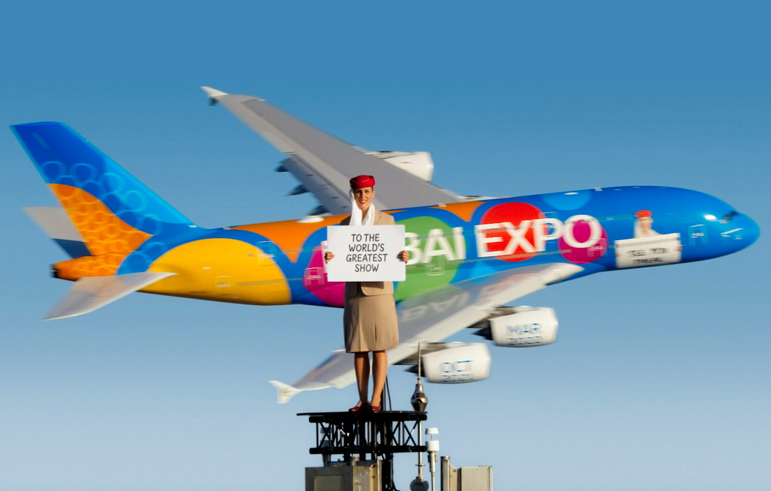 Совместная рекламная кампания Emirates и Expo 2020 Dubai. Каскадер Николь Смит-Людвик в одежде стюардессы стоит на вершине самого высокого здания в мире - небоскрёба Бурдж-Халифа - с рекламой шоу