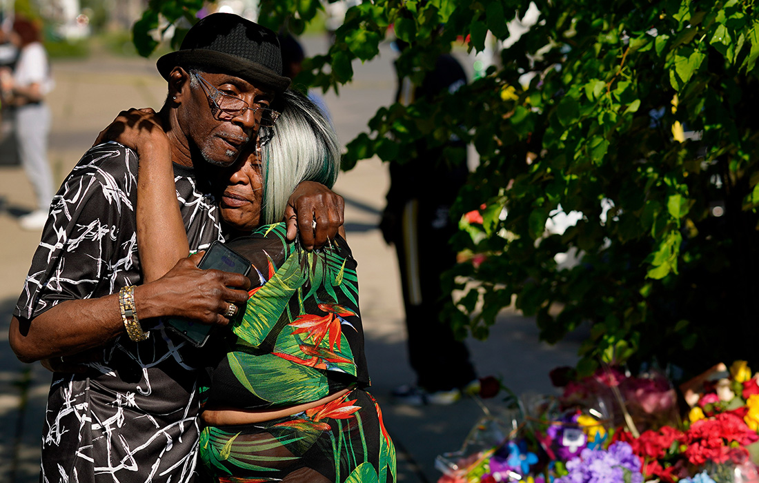 Люди скорбят около супермаркета американского города Буффало, где в результате стрельбы погибли десять человек