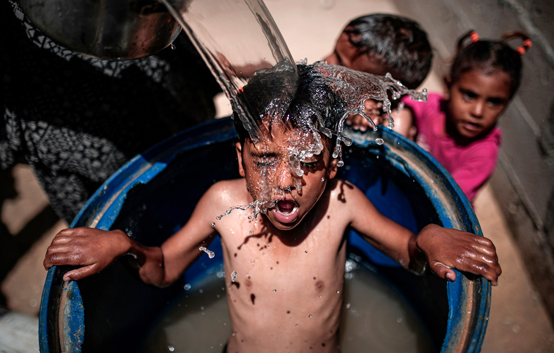 Дети охлаждаются во время жары в Газе